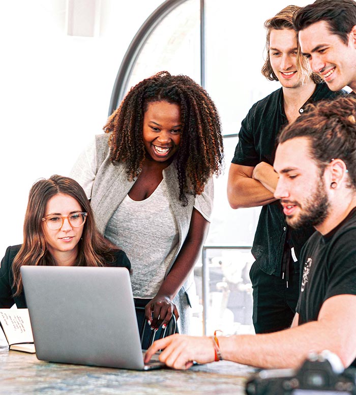 Startup team having a meeting looking over a laptop